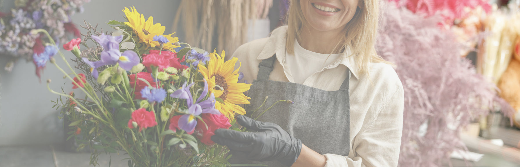 Florist arranging flowers with a colorful bouquet in a floral shop.